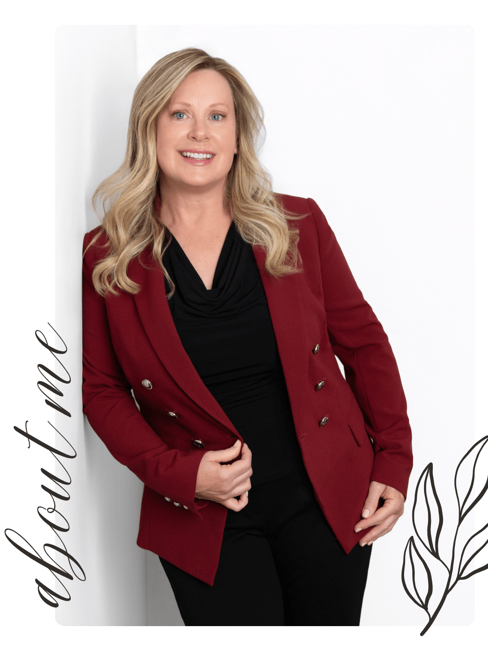 Professional business portrait of a smiling woman in a red blazer and black outfit, posed against a white background.